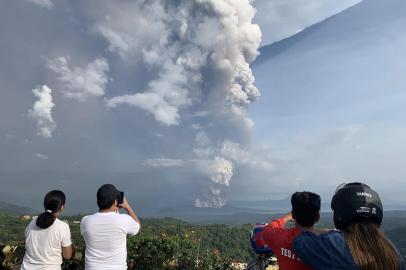 People take photos of a phreatic explosion from the Taal volcano as seen from the town of Tagaytay in Cavite province, southwest of Manila, on January 12, 2020. (Photo by Bullit MARQUEZ / AFP)<!-- NICAID(14384528) -->