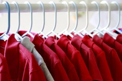  PORTO ALEGRE, RS, BRASIL, 03/09/2017- Uniforme escolar em cabides. Varias camisas vermelhas e uma cinza. Foco seletivo. Foto: stock.adobe.com / GalinaStFonte: 170171965