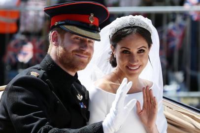 (FILES) In this file photo taken on May 19, 2018 Britains Prince Harry, Duke of Sussex and his wife Meghan, Duchess of Sussex wave from the Ascot Landau Carriage during their carriage procession on the Long Walk as they head back towards Windsor Castle in Windsor, oafter their wedding ceremony. - Britains Prince Harry and his wife Meghan will step back as senior members of the royal family and spend more time in North America, the couple said in a historic statement Wednesday. (Photo by Aaron Chown / POOL / AFP)