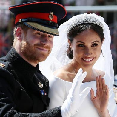 (FILES) In this file photo taken on May 19, 2018 Britains Prince Harry, Duke of Sussex and his wife Meghan, Duchess of Sussex wave from the Ascot Landau Carriage during their carriage procession on the Long Walk as they head back towards Windsor Castle in Windsor, oafter their wedding ceremony. - Britains Prince Harry and his wife Meghan will step back as senior members of the royal family and spend more time in North America, the couple said in a historic statement Wednesday. (Photo by Aaron Chown / POOL / AFP)