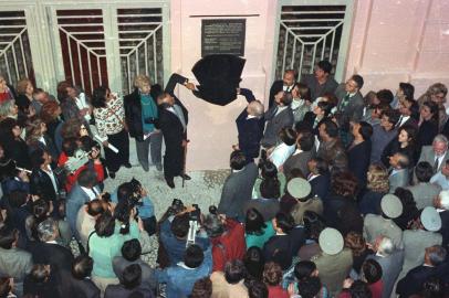 Governador Synval Guazzelli e o poeta Mario Quintana durante o  descerramento da placa de reinauguração da CCMQ. Mais de mil pessoas participaram dia 25/09/1990 da reabertura da Casa de Cultura Mario Quintana. O poeta Mario Quintana foi a grande estrela da festa e falou do que mais sabe: de sua poesia e de Porto Alegre.Desde o início da tarde a multidão aguardava a abertura do prédio do antigo Hotel Magestic, residência do poeta por mais de dez anos. A inauguração só teve início oficialmente quando chegaram os convidados especiais por volta das 18h.Na década de 70 o hotel foi desativado. A partir de 30/08/1985, quando o prédio passou a integrar o patrimônio histórico e artístico nacional, foi que teve início a luta pela transformação do hotel em casa de cultura. Nesse momento a Casa de Cultura já existia como órgão oficial, criado pela lei 7803, de 08/07/1983. #ENVELOPE: 96038<!-- NICAID(1820132) -->