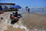 Com maré alta, veranistas se encolhem em pequena faixa de areia no Litoral