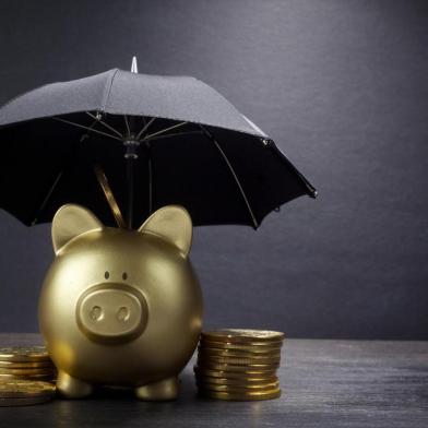 Gold Piggy bank with umbrella concept for finance insurance, protection, safe investment or bankingPORTO ALEGRE, RS, BRASIL,17/10/2019- Cofrinho de ouro com conceito de guarda-chuva para financiamento de seguros, proteção, investimento seguro ou bancário. (Foto: vetre / stock.adobe.com)Fonte: 272268052<!-- NICAID(14293645) -->