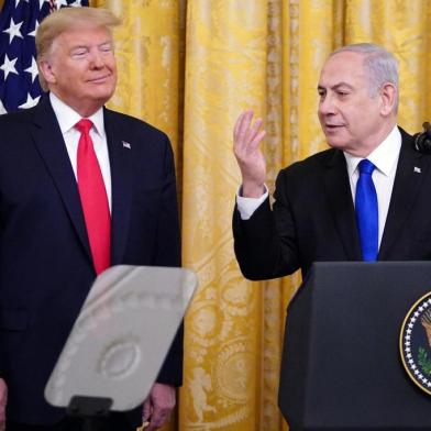 Israeli Prime Minister Benjamin Netanyahu, with US President Donald Trump, speaks during an announcement of Trumps Middle East peace plan in the East Room of the White House in Washington, DC on January 28, 2020. - Trump declared that Israel was taking a big step towards peace as he unveiled a plan aimed at solving the Israeli-Palestinian conflict. Today, Israel takes a big step towards peace, Trump said, standing alongside Netanyahu as he revealed details of the plan already emphatically rejected by the Palestinians. (Photo by MANDEL NGAN / AFP)<!-- NICAID(14401046) -->