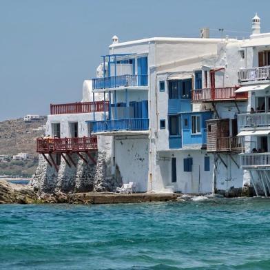 Mykonos13 June 2019, Greece, Mykonos: Residential and commercial buildings on the shore of the island of Mykonos. The holiday island in the Aegean Sea is one of the most popular destinations for holidaymakers and is known for its summer party atmosphere. The islands landmarks are the 16th century windmills, which stand side by side on a hill above the town and are visible from afar. Photo: Soeren Stache/dpa-Zentralbild/ZBEditoria: LIFLocal: MykonosIndexador: SOEREN STACHEFonte: dpa-Zentralbild<!-- NICAID(14408113) -->