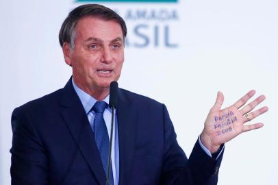  Brazils President Jair Bolsonaro writes on the palm of his hand during a ceremony to mark his 400 days in office at the Planalto palace, in Brasilia, Brazil, on  February 5, 2020. (Photo by Sergio LIMA / AFP)Editoria: POLLocal: BrasíliaIndexador: SERGIO LIMASecao: governmentFonte: AFPFotógrafo: STR<!-- NICAID(14410122) -->