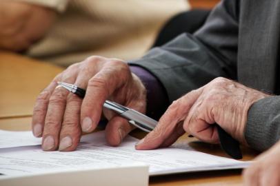  An elderly man writes a pen in the questionnaire. Old age and learning. Unemployment and retirement. No face                               Fonte: 266815937<!-- NICAID(14411027) -->