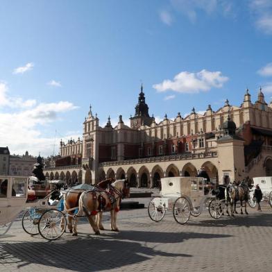 Horse carriages stand near the Cloth Hall building in the old city center in Krakow on Febuary 5, 2020. (Photo by Ludovic MARIN / AFP)<!-- NICAID(14410423) -->