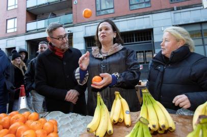 Irish republican Sinn Fein party leader Mary Lou McDonald (C) throws oranges in the air as she talks with a fruit trader (R) during a walkabout in the centre of Dublin, Ireland on February 10, 2020. - Mary Lou McDonalds leadership has transformed Sinn Fein into a party deemed worthy of power in Ireland, rather than merely the political voice of the IRA. Under her direction, Sinn Fein topped the first preference votes in Irelands general election on 24.5 percent -- a 10.7 percentage point boost from the leftist partys showing in 2016. (Photo by PAUL FAITH / AFP)<!-- NICAID(14414379) -->