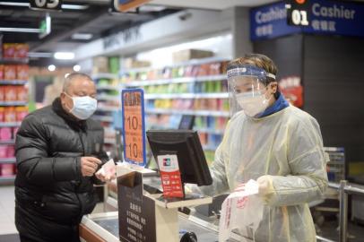 A staff member wearing a protective mask and suit works at a supermarket in Wuhan, the epicentre of the outbreak of a novel coronavirus, in China's central Hubei province. The death toll from the novel coronavirus surged past 900 in mainland China on February 10, overtaking global fatalities in the 2002-03 SARS epidemic, even as the World Health Organization said<!-- NICAID(14415169) -->