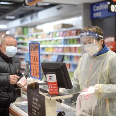 A staff member wearing a protective mask and suit works at a supermarket in Wuhan, the epicentre of the outbreak of a novel coronavirus, in Chinas central Hubei province. The death toll from the novel coronavirus surged past 900 in mainland China on February 10, overtaking global fatalities in the 2002-03 SARS epidemic, even as the World Health Organization said<!-- NICAID(14415169) -->