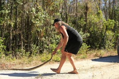 Dusty Crum catches snake on levee