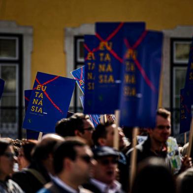 People attend a protest against the decriminalization of euthanasia in front of the parliament on February 20, 2020 in Lisbon as lawmakers debate bills on euthanasia. - The Portuguese Parliament examines today several texts in favor of the decriminalization of euthanasia, narrowly rejected almost two years ago. (Photo by PATRICIA DE MELO MOREIRA / AFP)<!-- NICAID(14426189) -->