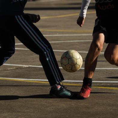  CAXIAS DO SUL, RS, BRASIL, 09/06/2014. Fotos para ensaio fotográfico da contracapa do Pioneiro, com a temática futebol. Meninos jogam bola na quadra em frente à UBS Santa Lúcia, em Caxias, na semana de abertura da copa do mundo 2014. (Diogo Sallaberry/Agência RBS)Indexador: Diogo Sallaberry<!-- NICAID(10563095) -->