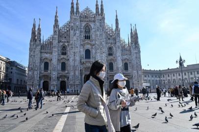  Two women wearing a protective facemask walk across the Piazza del Duomo, in front of the Duomo, in central Milan, on February 24, 2020 closed following security measures taken in northern Italy against the COVID-19 the novel coronavirus. - Italy reported on February 24, 2020 its fourth death from the new coronavirus, an 84-year old man in the northern Lombardy region, as the number of people contracting the virus continued to mount. (Photo by ANDREAS SOLARO / AFP)Editoria: HTHLocal: MilanIndexador: ANDREAS SOLAROSecao: diseaseFonte: AFPFotógrafo: STF