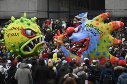  Carnival revellers crowd at the roadside and watch a float depicting the carnival virus (R) making a fool of the coronavirus during the Rose Monday carnival street parade in Duesseldorf, western Germany on February 24, 2020. (Photo by Ina Fassbender / AFP)Editoria: ACELocal: DüsseldorfIndexador: INA FASSBENDERSecao: customs and traditionFonte: AFPFotógrafo: STR