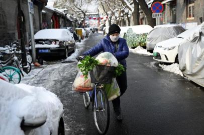  A woman wearing a protective face mask pushes her bicycle with bags of vegetables in an alley in Beijing on February 7, 2020. - The official Chinese death toll from the coronavirus outbreak rose on February 7 to 636, with the government saying total infections had climbed past 30,000. (Photo by - / AFP)Editoria: HTHLocal: BeijingIndexador: -Secao: healthcare policyFonte: AFPFotógrafo: STR<!-- NICAID(14411801) -->