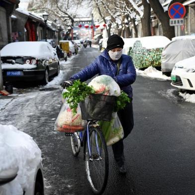  A woman wearing a protective face mask pushes her bicycle with bags of vegetables in an alley in Beijing on February 7, 2020. - The official Chinese death toll from the coronavirus outbreak rose on February 7 to 636, with the government saying total infections had climbed past 30,000. (Photo by - / AFP)Editoria: HTHLocal: BeijingIndexador: -Secao: healthcare policyFonte: AFPFotógrafo: STR<!-- NICAID(14411801) -->