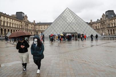 Two people walk away from the Pyramid, the main entrance to the Louvre museum which was once a royal residence, located in central in Paris on March 2, 2020. - The Louvre in Paris, the worlds most visited museum, was closed for a second day running on March 2, 2020, after staff refused for a second day running to work due to coronavirus fears, a union said. The Paris museum insisted that closure was not necessary in response to fears over the virus, which has spread to over 60 countries after first emerging in China late last year. (Photo by Ludovic Marin / AFP)Editoria: HTHLocal: ParisIndexador: LUDOVIC MARINSecao: diseaseFonte: AFPFotógrafo: STF<!-- NICAID(14436817) -->