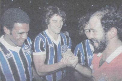 Foto publicada na Zero Hora de 27 de janeiro de 1984. Ex-companheiros de equipe cumprimentam Mário Sérgio, que jogou o Gre-Nal da colocação de faixas pelo Inter, mas ganhou a faixa de campeão do mundo pelo Grêmio.<!-- NICAID(10170108) -->