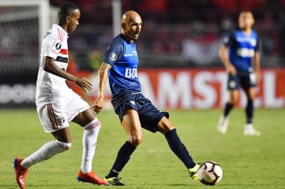 Helinho (L) of Brazils Sao Paulo vies for the ball with Pablo Guinazu (R) of Argentinas Talleres during their 2019 Copa Libertadores football match held at Morumbi stadium, in Sao Paulo, Brazil, on February 13, 2019. (Photo by NELSON ALMEIDA / AFP)<!-- NICAID(13957125) -->