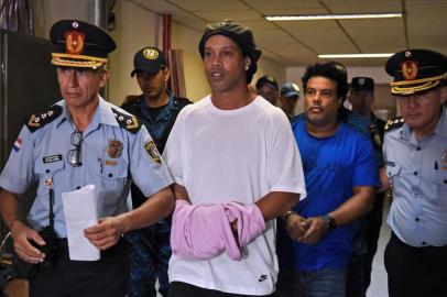  Brazilian retired football player Ronaldinho (C) and his brother Roberto Assis (R) arrive at Asuncions Justice Palace to appear before a public prosecutor who will decide whether to grant them bail or not following their irregular entry to the country, in Asuncion, on March 7, 2020. - Former Brazilian football star Ronaldinho and his brother have been detained in Paraguay after allegedly using fake passports to enter the South American country, authorities said Wednesday. (Photo by Norberto DUARTE / AFP)Editoria: CLJLocal: AsuncionIndexador: NORBERTO DUARTESecao: soccerFonte: AFPFotógrafo: STR<!-- NICAID(14443850) -->