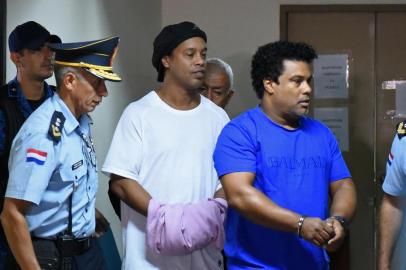  Brazilian retired football player Ronaldinho (C) and his brother Roberto Assis (R) arrive at Asuncion's Justice Palace to appear before a public prosecutor who will decide whether to grant them bail or not following their irregular entry to the country, in Asuncion, on March 7, 2020. - Former Brazilian football star Ronaldinho and his brother have been detained in Paraguay after allegedly using fake passports to enter the South American country, authorities said Wednesday. (Photo by Norberto DUARTE / AFP)Editoria: CLJLocal: AsuncionIndexador: NORBERTO DUARTESecao: soccerFonte: AFPFotógrafo: STR<!-- NICAID(14445407) -->