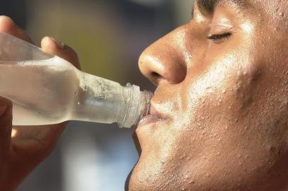 Forte Calor em Porto Alegre durante o outono. Pessoa bebendo água mineral.#Máquina: D1-5021709calor seca  água_mineral  verão em abril  outono quente<!-- NICAID(1550500) -->