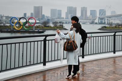  A couple stands before the Olympic Rings at Odaiba Seaside Park in Tokyo on March 8, 2020. - Construction of all new permanent venues for the Tokyo 2020 Olympics and Paralympics is now complete, organisers said on March 6, as preparations continue despite worries over the new coronavirus outbreak. (Photo by CHARLY TRIBALLEAU / AFP)Editoria: SPOLocal: TokyoIndexador: CHARLY TRIBALLEAUSecao: sports eventFonte: AFPFotógrafo: STF<!-- NICAID(14449282) -->