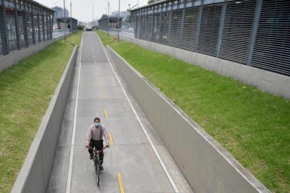 Man rides his bicycle using a face mask as a preventive measure in the face of the global COVID-19 coronavirus pandemic, in Bogota on March 13, 2020. - Colombia declared on March 12, 2020 a "Health Emergency" due to the new coronavirus pandemic, a figure that allows it to take exceptional measures such as prohibiting the disembarkation of cruise ships and the holding of public events with more than 500 attendees. (Photo by Raul ARBOLEDA / AFP)<!-- NICAID(14451660) -->