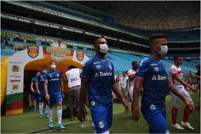 Jogadores do Grêmio entram em campo, na Arena, com máscaras em protesto à manutenção dos jogos no Gauchão