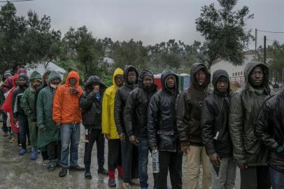 ISLAND-MAGRA-ART-NSPR-040318Refugees, mostly from Cameroon and Congo, queue up to receive breakfast, reportedly only a bottle of water and a croissant, at the makeshift camp outside Moria, on the Greek island of Lesbos, Feb. 27, 2018. Two years after the European Union and Turkey struck a deal to cut off asylum seekers crossing the Aegean, thousands languish in deplorable conditions on Lesbos. (Mauricio Lima/The New York Times)Editoria: ILocal: LESBOS ISLANDIndexador: MAURICIO LIMAFonte: NYTNSFotógrafo: STR<!-- NICAID(13508277) -->