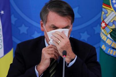  Brazilian President Jair Bolsonaro covers his face with a face mask during a press conference regarding the COVID-19, coronavirus pandemic at the Planalto Palace, Brasilia on March 18, 2020. (Photo by Sergio LIMA / AFP)Editoria: HTHLocal: BrasíliaIndexador: SERGIO LIMASecao: governmentFonte: AFPFotógrafo: STR<!-- NICAID(14455488) -->