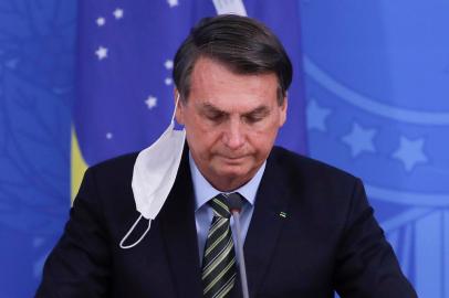  Brazilian President Jair Bolsonaro gestures during a press conference regarding the COVID-19, coronavirus pandemic at the Planalto Palace, Brasilia on March 18, 2020. (Photo by Sergio LIMA / AFP)Editoria: HTHLocal: BrasíliaIndexador: SERGIO LIMASecao: governmentFonte: AFPFotógrafo: STR<!-- NICAID(14455620) -->