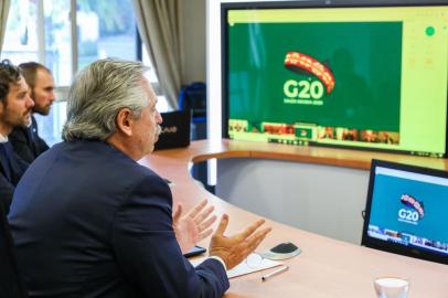  Handout photo released by Argentinas Presidency of Argentine President Alberto Fernandez (R) talking during the G20s video conference meeting next to Argentine chief cabinet Santiago Cafiero (L) and Argentinas Economy minister Martin Guzman (2nd L) at the Olivos Presidential residence in Buenos Aires outskirts, on March 26, 2020 during the preventative and compulsory lockdown of the population due to the pandemic outbreak of the new Coronavirus, COVID-19. - G20s leaders meet urgently to address the global crisis caused by the new coronavirus, which has already left nearly 22,000 dead and forces 3,000 million people around the world to confine themselves to their homes. (Photo by - / Argentinian Presidency / AFP) / RESTRICTED TO EDITORIAL USE - MANDATORY CREDIT AFP PHOTO / ARGENTINE PRESIDENCY / ESTEBAN COLLAZO - NO MARKETING NO ADVERTISING CAMPAIGNS - DISTRIBUTED AS A SERVICE TO CLIENTSEditoria: POLLocal: OlivosIndexador: -Secao: diplomacyFonte: Argentinian PresidencyFotógrafo: Handout<!-- NICAID(14461944) -->