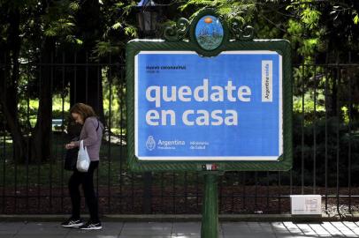  A woman walks near a board advertising Health Ministry advise reading "Stay at home" during the outbreak of the new Coronavirus, COVID-19, in Buenos Aires, Argentina on March 19, 2020. (Photo by JUAN MABROMATA / AFP)Editoria: HTHLocal: Buenos AiresIndexador: JUAN MABROMATASecao: economy (general)Fonte: AFPFotógrafo: STF<!-- NICAID(14456872) -->