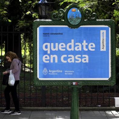  A woman walks near a board advertising Health Ministry advise reading "Stay at home" during the outbreak of the new Coronavirus, COVID-19, in Buenos Aires, Argentina on March 19, 2020. (Photo by JUAN MABROMATA / AFP)Editoria: HTHLocal: Buenos AiresIndexador: JUAN MABROMATASecao: economy (general)Fonte: AFPFotógrafo: STF<!-- NICAID(14456872) -->