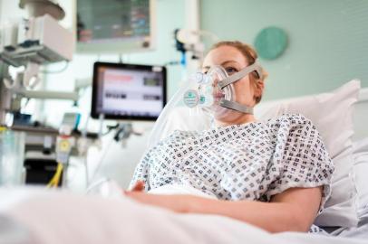 An undated handout image released by University College London (UCL) in London and received on March 30, 2020, shows a volunteer patient posing whilst wearing the Continuous Positive Airway Pressure (CPAP) breathing aid, developed in less than a week by mechanical engineers, doctors and the Mercedes Formula 1 team in conjunction with UCL. - Medical researchers and engineers at UCL have teamed up with Formula One outfit Mercedes to adapt a breathing aid for mass production that could keep coronavirus patients off much-needed ventilators. University College London said UK regulators had approved its adaptation of the continuous positive airway pressure device (CPAP), which helps patients with breathing difficulties. A version of the equipment, which increases air and oxygen flow into the lungs, has already been used in hospitals in Italy and China to help COVID-19 patients with serious lung infections. (Photo by James Tye / University College London (UCL) / AFP) / RESTRICTED TO EDITORIAL USE - MANDATORY CREDIT AFP PHOTO / James Tye/ UCL / Handout  - NO MARKETING - NO ADVERTISING CAMPAIGNS - DISTRIBUTED AS A SERVICE TO CLIENTS<!-- NICAID(14464533) -->