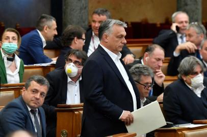 Hungarian Prime Minister Viktor Orban (C) walks near other representatives during a vote about the governments bill on the protection against the new coronavirus COVID-19 at the plenary session of the Hungarian Parliament in Budapest, Hungary on March 30, 2020.