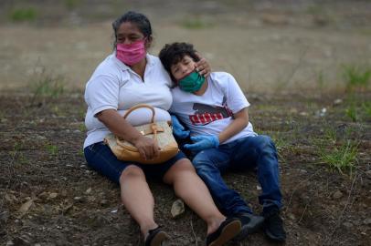  Relatives of a deceased person wearing face masks mourn outside a cemetery in Guayaquil, Ecuador on April 1, 2020. - Residents of Guayaquil, in Ecuadors southwest, express outrage over the way the government has responded to the numerous deaths related to the novel coronavirus, COVID-19, saying there are many more deaths than are being reported and that bodies are being left in homes for days without being picked up. Ecuador marked its highest daily increase in deaths and new cases of coronavirus on Sunday, with the total reaching 14 dead and 789 infected, authorities had said. (Photo by Marcos Pin / AFP)Editoria: HTHLocal: GuayaquilIndexador: MARCOS PINSecao: diseaseFonte: AFPFotógrafo: STR<!-- NICAID(14467617) -->