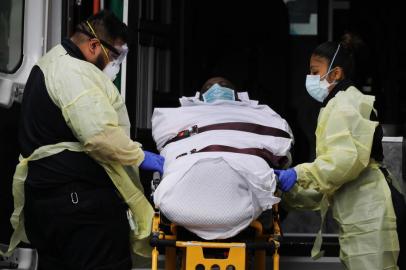 NEW YORK, NY APRIL 04: Health workers walk with a patient outside of Mount Sinai Hospital which has seen an upsurge of coronavirus patients on April 04, 2020 in New York City. Hospitals in New York City, which has been especially hard hit by the coronavirus, are facing shortages of beds, ventilators and protective equipment for medical staff. Currently, over 75, 000 New Yorkers have tested positive for COVID-19.   Spencer Platt/Getty Images/AFP<!-- NICAID(14469306) -->