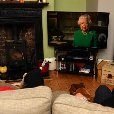  A picture shows a family in Birkenhead, northwest England on April 5, 2020 watching Britains Queen Elizabeth II deliver a special address to the UK and  Commonwealth recorded at Windsor Castle in relation to the coronavirus outbreak. - Queen Elizabeth II urgeed people to rise to the challenge posed by the coronavirus outbreak, in a rare special address to Britain and Commonwealth nations on Sunday. (Photo by PAUL ELLIS / AFP)Editoria: HUMLocal: BirkenheadIndexador: PAUL ELLISSecao: diseaseFonte: AFPFotógrafo: STF<!-- NICAID(14469565) -->