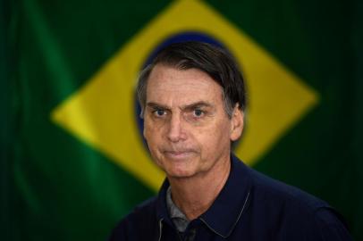  O candidato à Presidência da República pelo PSL, Jair Bolsonaro, vota no primeiro turno das Eleições 2018 na Vila Militar, em Marechal Hermes, na zona norte da cidade, neste domingo, 7.Brazils right-wing presidential candidate for the Social Liberal Party (PSL) Jair Bolsonaro walks in front of the Brazilian flag as he prepares to cast his vote during the general elections, in Rio de Janeiro, Brazil, on October 7, 2018.Polling stations opened in Brazil on Sunday for the most divisive presidential election in the country in years, with far-right lawmaker Jair Bolsonaro the clear favorite in the first round. About 147 million voters are eligible to cast ballots and choose who will rule the worlds eighth biggest economy. New federal and state legislatures will also be elected. / AFP PHOTO / Mauro PIMENTELEditoria: POLLocal: Rio de JaneiroIndexador: MAURO PIMENTELSecao: electionFonte: AFPFotógrafo: STF<!-- NICAID(13774277) -->