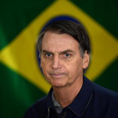  O candidato à Presidência da República pelo PSL, Jair Bolsonaro, vota no primeiro turno das Eleições 2018 na Vila Militar, em Marechal Hermes, na zona norte da cidade, neste domingo, 7.Brazil's right-wing presidential candidate for the Social Liberal Party (PSL) Jair Bolsonaro walks in front of the Brazilian flag as he prepares to cast his vote during the general elections, in Rio de Janeiro, Brazil, on October 7, 2018.Polling stations opened in Brazil on Sunday for the most divisive presidential election in the country in years, with far-right lawmaker Jair Bolsonaro the clear favorite in the first round. About 147 million voters are eligible to cast ballots and choose who will rule the world's eighth biggest economy. New federal and state legislatures will also be elected. / AFP PHOTO / Mauro PIMENTELEditoria: POLLocal: Rio de JaneiroIndexador: MAURO PIMENTELSecao: electionFonte: AFPFotógrafo: STF<!-- NICAID(13774277) -->
