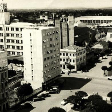 A esquina das ruas Sinimbu e Marquês do Herval sediou, ao longo das décadas, alguns dos estabelecimentos de negócio mais importantes da área central. Entram aí a Casa Minghelli, o Hotel Bela Vista e a Adega Pezzi.Na imagem, o trecho no final dos anos 1960. No final da década de 1960, o complexo da vinícola, que praticamente estendia-se quase até a Rua Os Dezoito do Forte (detalhe ao lado), cedeu espaço a alguns dos primeiros arranha-céus de Caxias, os edifícios Dona Ercília e Marina. Na foto, à direita, vemos os tapumes que então cercavam o terreno do Dona Ercília. Na foto aparecem ainda o Hotel Menegotto, a Metalúrgica Abramo Eberle, o Hotel Bela Vista e a sede da Festa da Uva (hoje prefeitura de Caxias). <!-- NICAID(10692892) -->