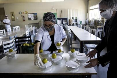  PORTO ALEGRE, RS, BRASIL, 20-04-2020: Distribuição de marmitas para moradores em situação de rua e famílias carentes no refeitório Mãe Aparecida, no Centro Social Padre Pedro Leonardi, no bairro Restinga. O terceiro restaurante popular da cidade, chamado Prato Alegre, com capacidade para oferecer 100 refeições diárias, foi inaugurado hoje no espaço do centro social na Chácara do Banco, mas as instalações não receberam usuários. Para evitar aglomerações, foi utilizado o refeitório Mãe Aparecida, que tem área mais ampla. Devido à pandemia, as refeições são servidas no sistema de marmitas, conforme a prefeitura. (Foto: Mateus Bruxel / Agência RBS)Indexador: Mateus Bruxel