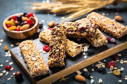 Granola bar with nuts, fruit and berries on black.PORTO ALEGRE, RS, BRASIL,22/04/2020-Barra de sereal, Granola, alimentação saudável. Foto: nadianb / stock.adobe.comFonte: 266606306<!-- NICAID(14483399) -->