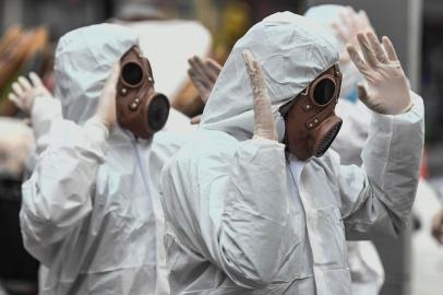 Youngsters wearing protective suites take part in a performance as part of an awareness campaign against the spread of the new coronavirus, COVID-19, in Bogota on March 18, 2020. - Colombian President Ivan Duque declared a state of emergency, asking citizens older than 70 to remain indoors. (Photo by Juan BARRETO / AFP)<!-- NICAID(14456174) -->