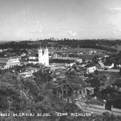 Panorâmica do bairro Lourdes nos anos 1950, a partir dos altos da Rua Pinheiro Machado. Vê-se a Avenida Júlio de Castilhos, o casarão de madeira de Vicente Rovea (ao centro), a Casa de Negócios de Vicente Rovea à direita  (antigo Hospital Carbone e atual sede do Arquivo Histórico Municipal João Spadari Adami), a Igreja de Nossa Senhora de Lourdes e parte da Vinícola Luiz Michiielon, com a antiga chaminé.<!-- NICAID(14485363) -->