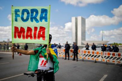  A supporter of anti-quarantine Brazilian President Jair Bolsonaro holds a banner reading Maia Out during a motorcade against the president of the Chamber of Deputies Rodrigo Maia and the quarantine and social distance measures imposed by governors and mayors to combat the novel coronavirus COVID-19 outbreak, in Brasilia on April 26, 2020. - A total of 202,994 people have died worldwide since the epidemic surfaced in China in December, according to an AFP tally at 1100 GMT Sunday based on official sources. (Photo by Sergio LIMA / AFP)Editoria: HTHLocal: BrasíliaIndexador: SERGIO LIMASecao: diseaseFonte: AFPFotógrafo: STR<!-- NICAID(14486221) -->